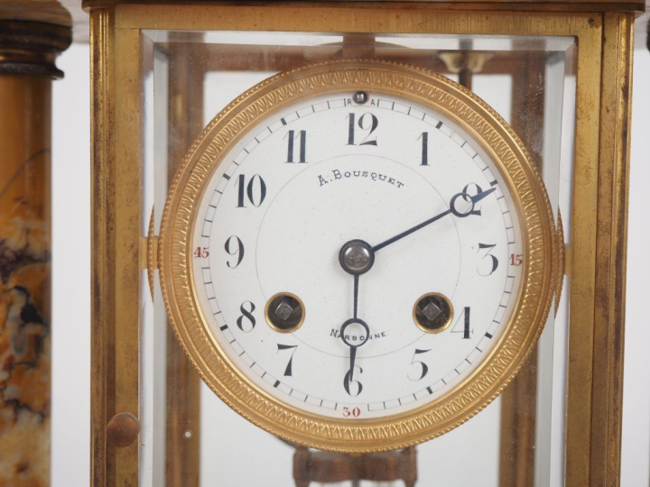 Garniture de cheminée en marbre et laiton comprenant une pendule porti