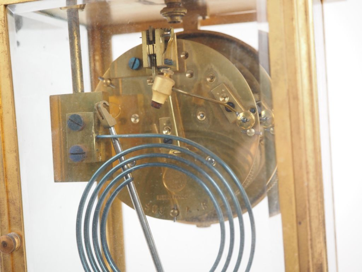 Garniture de cheminée en marbre et laiton comprenant une pendule porti