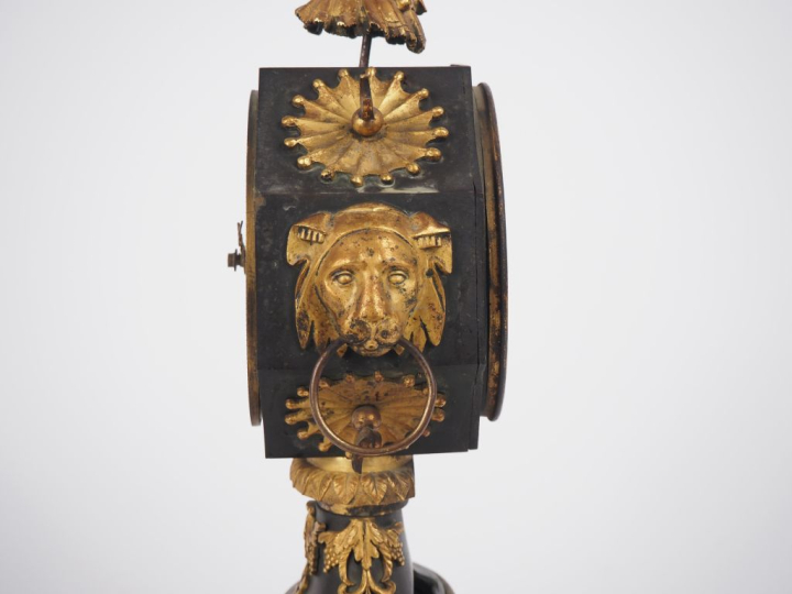 Pendule de style Empire en bronze patiné vert et doré, à décor de visa