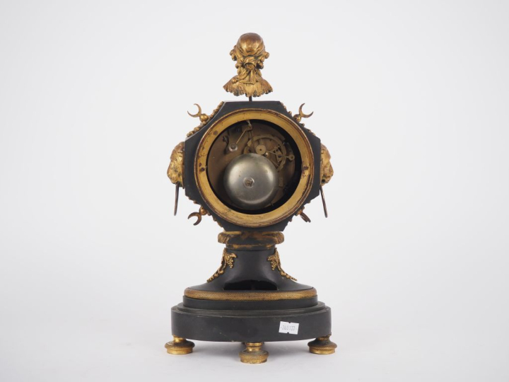 Pendule de style Empire en bronze patiné vert et doré, à décor de visa