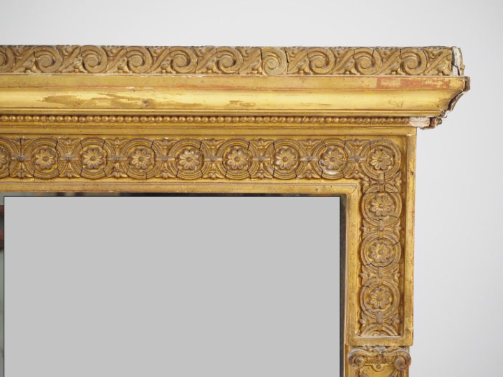 Glace XIXème de style Empire, cadre en stuc doré à décor de pilastres 