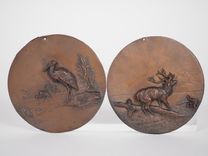 Paire de médaillons en métal patiné à décor d'échassiers. Diam. 10,5 c