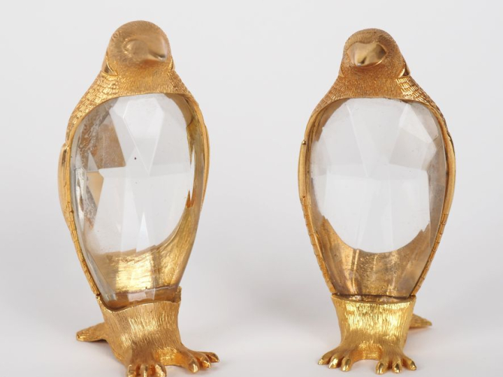 Paire de sujets en métal doré et verre taillé, "pingouins". H. 9,5 cm.