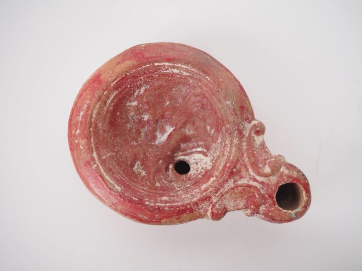 Lampe en terre cuite au médaillon orné d’une victoire sur un char. Tra
