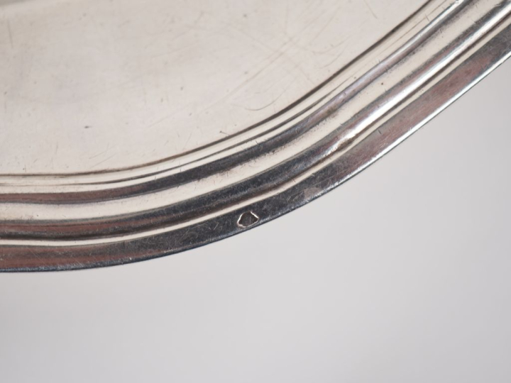 Petit plat rond XVIIIème en argent, modèle à filets.  Bord chantourné.