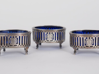 Vente aux enchères Garniture de table XVIIIème en argent comprenant trois salerons, à déc