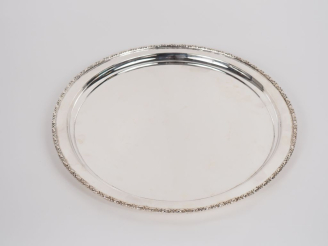 Vente aux enchères Grand plat rond en métal argenté, à décor d'une frise de feuillage et 