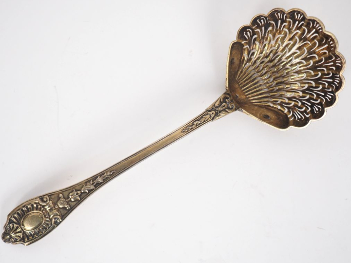 Cuillère à saupoudrer en argent doré, à décor de coquille et cartouche
