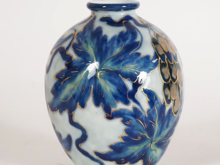 THARAUD.  Vase ovoide en porcelaine à décor de pampres en bleu et vert
