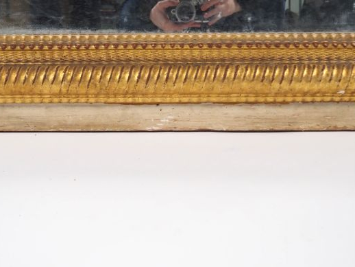 Glace de cheminée Napoléon III en bois et stuc doré, cadre guilloché. 