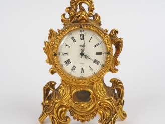 Vente aux enchères LANCEL, Paris Pendulette de style Louis XV en métal doré. Cadran rond 