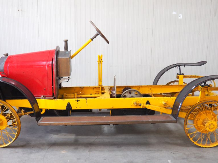 Base d'automobile début XXème avec différentes pièces dont moteur. (A 