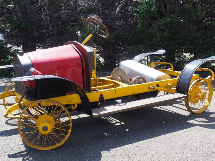 Base d'automobile début XXème avec différentes pièces dont moteur. (A 