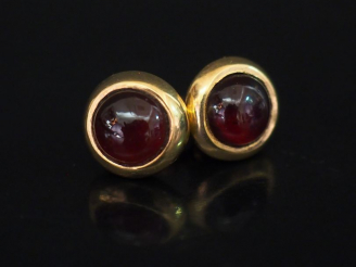Vente aux enchères Paire de perce oreilles en or et pierre rouge en cabochon. Diam. 1 cm 