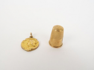Vente aux enchères Un dé et une médaille religieuse en or. 7 g