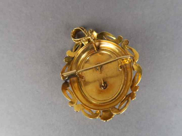Broche/Pendentif en or jaune, orné en son centre d'une perle. Poids te