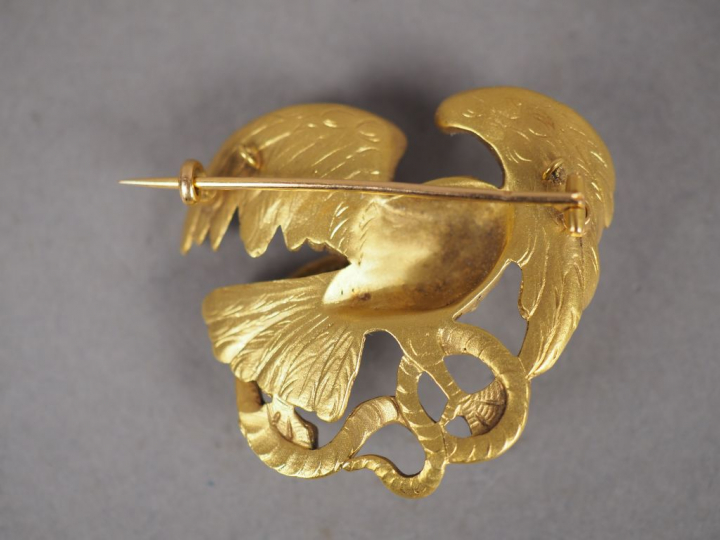 Broche en or jaune figurant un aigle et un serpent se battant. L'aigle