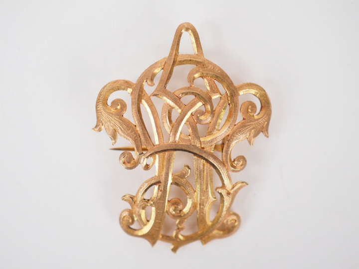 Broche en or jaune, à décor de monogramme. 4,5 x 3,5 cm  Poids. 9.77 g