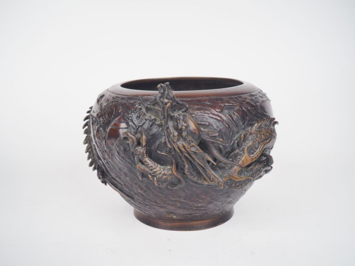 Coupe en bronze de patine brune rouge à décor d'un dragon en relief. J