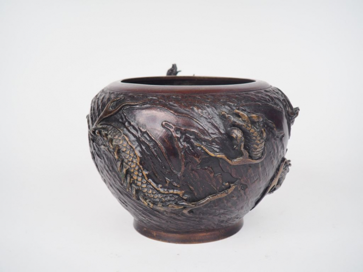Coupe en bronze de patine brune rouge à décor d'un dragon en relief. J