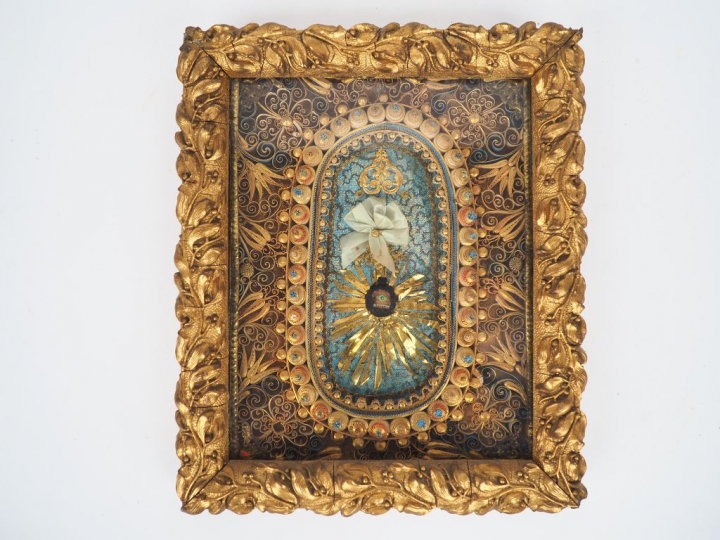 Reliquaire XIXème en paperolle dorée et polychrome, cadre en stuc à dé