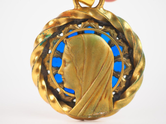 Vente aux enchères Médaille début Xxème figurant une Sainte Vierge de profil en métal dor
