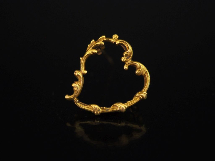Broche en or jaune 750 en forme de coeur, à décor de rinceaux.  2,7 x 