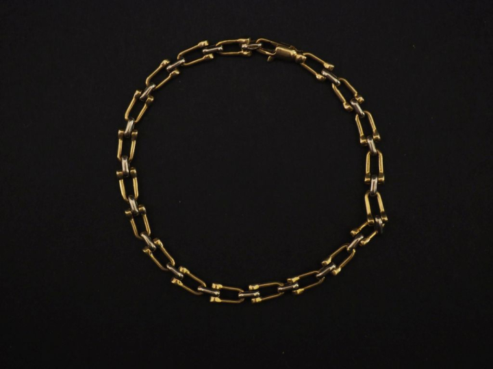 Bracelet deux tons d'or 750, à décor de poulies.  Long. 18,7 cm Poids.
