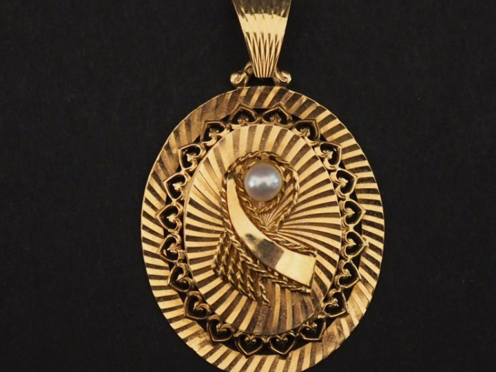 Pendentif de forme ovale en or jaune 750, à décor ajouré sur le pourto