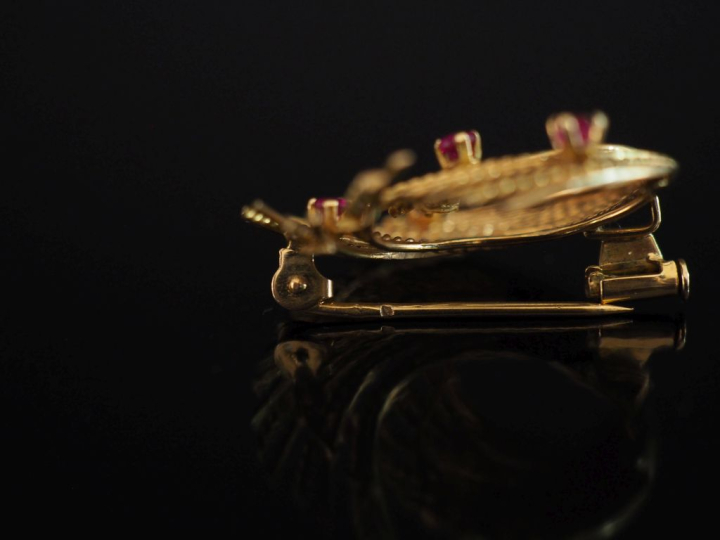 Broche de forme stylisée en or jaune 750, sertie de cinq pierres roses