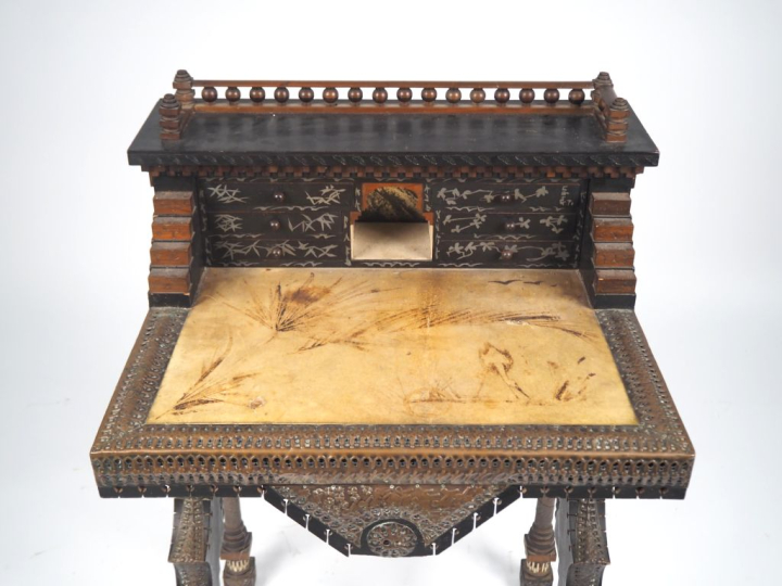 CARLO BUGATTI.  Secrétaire à gradins en bois teinté, noyer, parchemin,