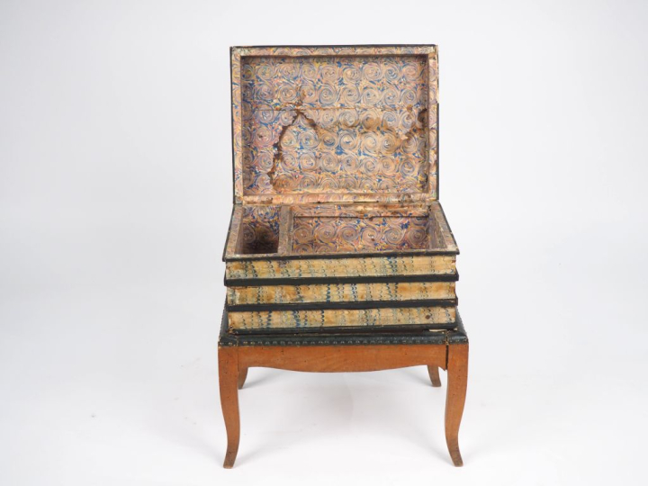 tabouret en trompe l'œil figurant une pile de livres, ouvrant à un aba