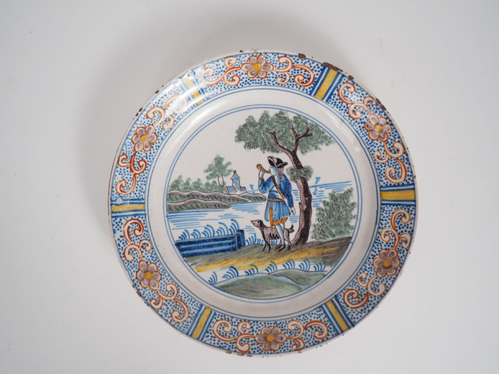 Assiette XVIIIème en faïence de Delft à décor polychrome figurant un c