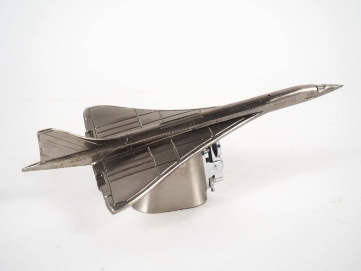 Briquet en métal argenté figurant le Concorde. Dim. 7,5 x 23 cm.