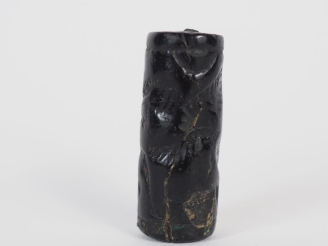 Vente aux enchères Orient ancien. Sceau cylindre en pierre noire décoré d’un personnage a