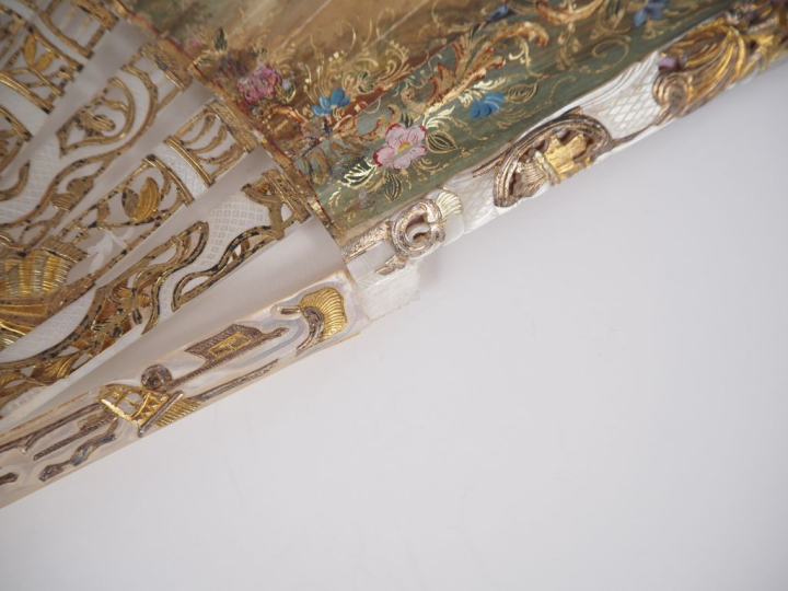 Eventail XVIIIème à feuilles pliées. Nacre ajourée et dorée à décor de