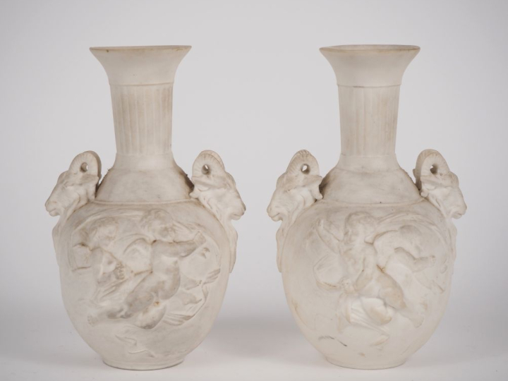Paire de vases en biscuit de style Louis XVI à décor d'amours et de bo