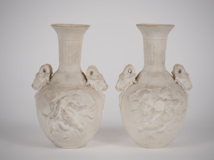 Paire de vases en biscuit de style Louis XVI à décor d'amours et de bo