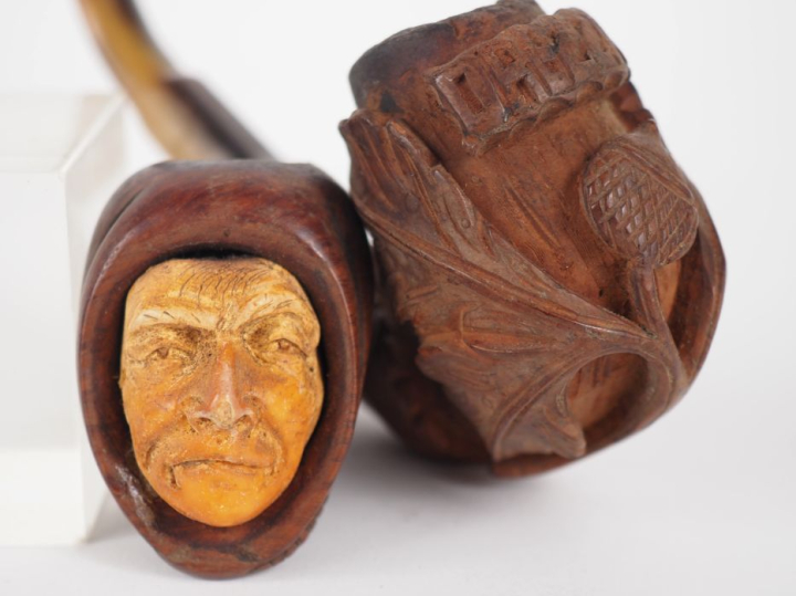 Deux différentes pipes en corne et bois sculpté, l'un figurant un visa