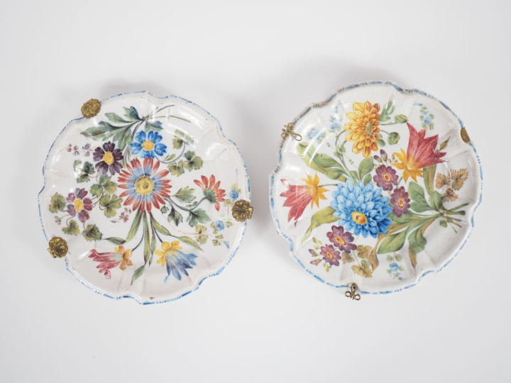 Deux assiettes en faïence italienne à décor polychrome de fleurs. Marq