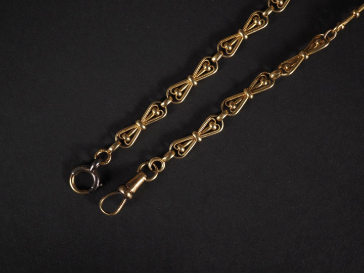 Giletière en or jaune 750, composée de maillons en forme de nœud, à dé