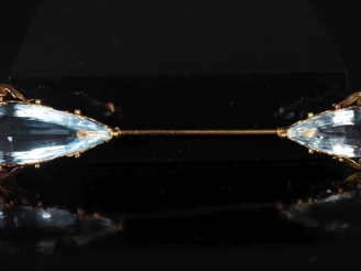 Vente aux enchères Broche en or jaune 750, sertie à ses extrémités d'une pierre bleu ciel