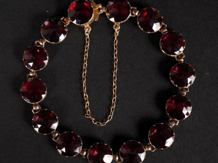 Bracelet souple en or jaune 750, serti de grenats.  Chainette de sécur