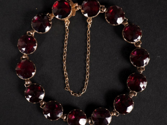 Vente aux enchères Bracelet souple en or jaune 750, serti de grenats.  Chainette de sécur