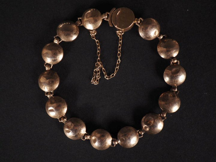 Bracelet souple en or jaune 750, serti de grenats.  Chainette de sécur