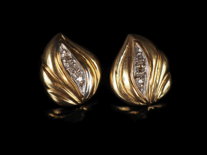 Paire de perces oreilles en forme de feuille, sertis en leur centre de