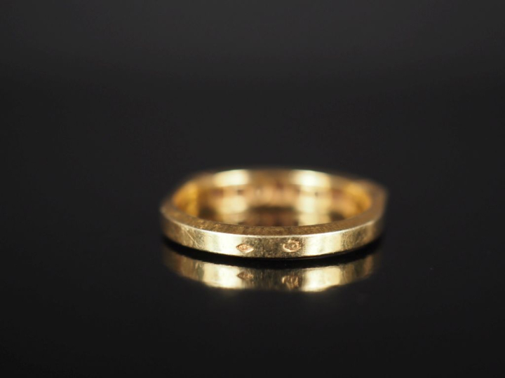 Bague jonc en or jaune 750, sertie de rubis calibrés et de deux petits