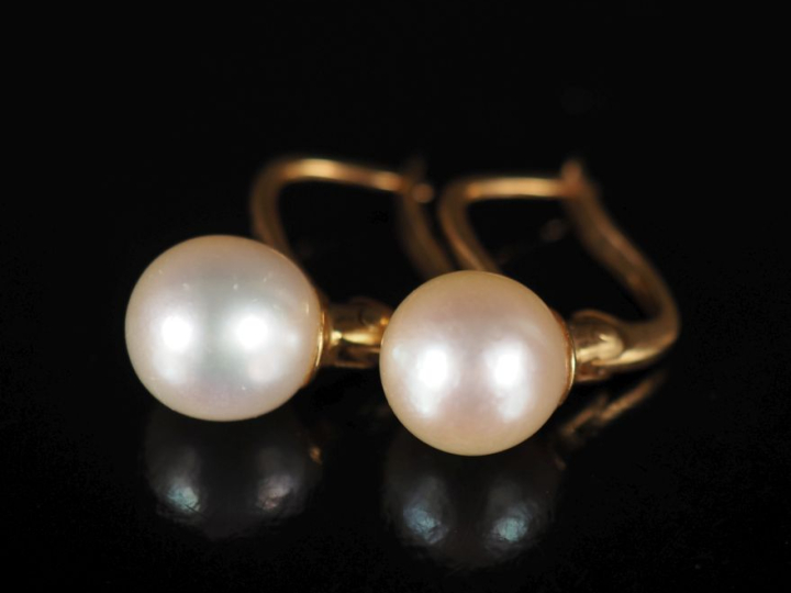 Paire de perces oreilles en or jaune 750, sertis d'une perle blanche. 