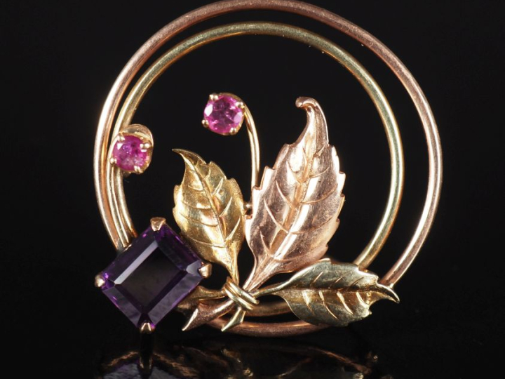 Broche circulaire ajourée deux tons d'or 375, à décor de branchage fle