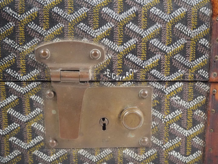 GOYARD Valise vintage en toile goyardine gainée de cuir marron.  Une a